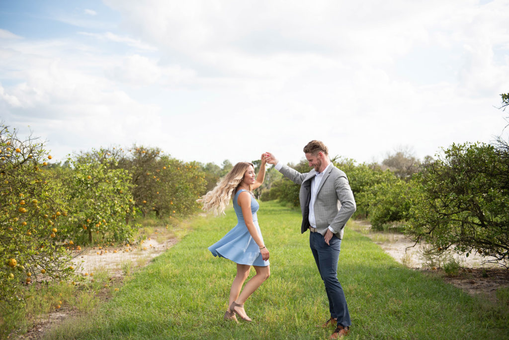Hancock Orange Groves Engagement Session Couple twirling at a farm
