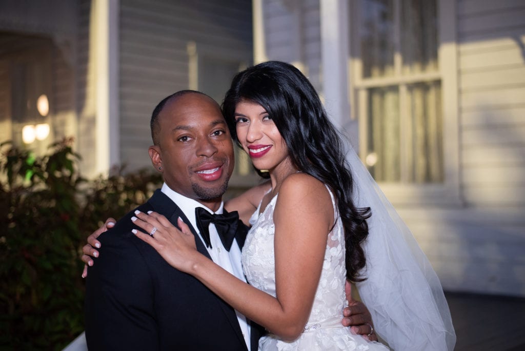 Ybor City Museum Garden wedding Bride and Groom hugging each other by white house in the evening wedding evening reception portrait