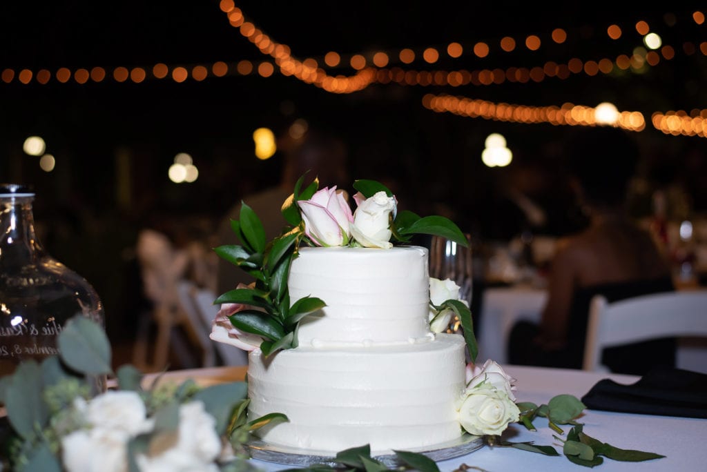 Ybor City Museum Garden Wedding Cake with flowers and lights in the background evening wedding reception