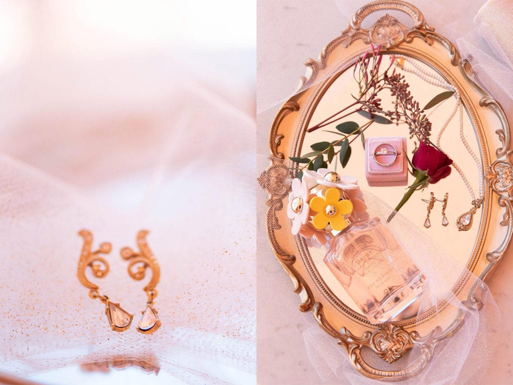 Hyatt Regency Clearwater Beach Wedding Bride's gold and diamond heirloom earrings, vintage gold mirror tray with Daisy by Marc Jacobs perfume, heirloom bridal necklace, wedding rings in Mrs Box velvet pink box and flowers on top of lace and marble counter