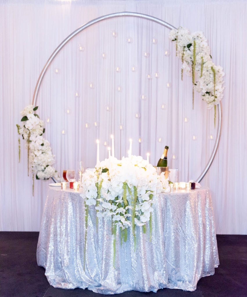 sweetheart table arch with candles white draping flowers silver decor at tampa airport marriott hotel grand ballroom