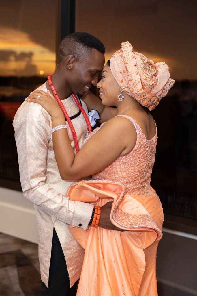tampa airport marriott sunset bride and groom portrait in haitian nigerian wedding traditional outfits in peach