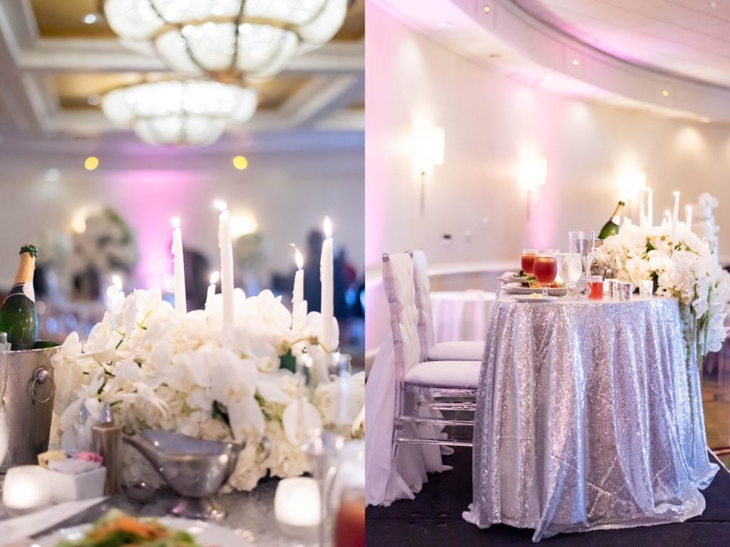 tampa airport marriott hotel grand ballroom wedding sweetheart table silver candles chandelier draping white flowers haitian nigerian wedding in tampa
