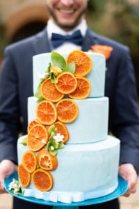Bok Tower Gardens Whimsical Citrus Wedding Blue fondant wedding cake with orange slices held by groom