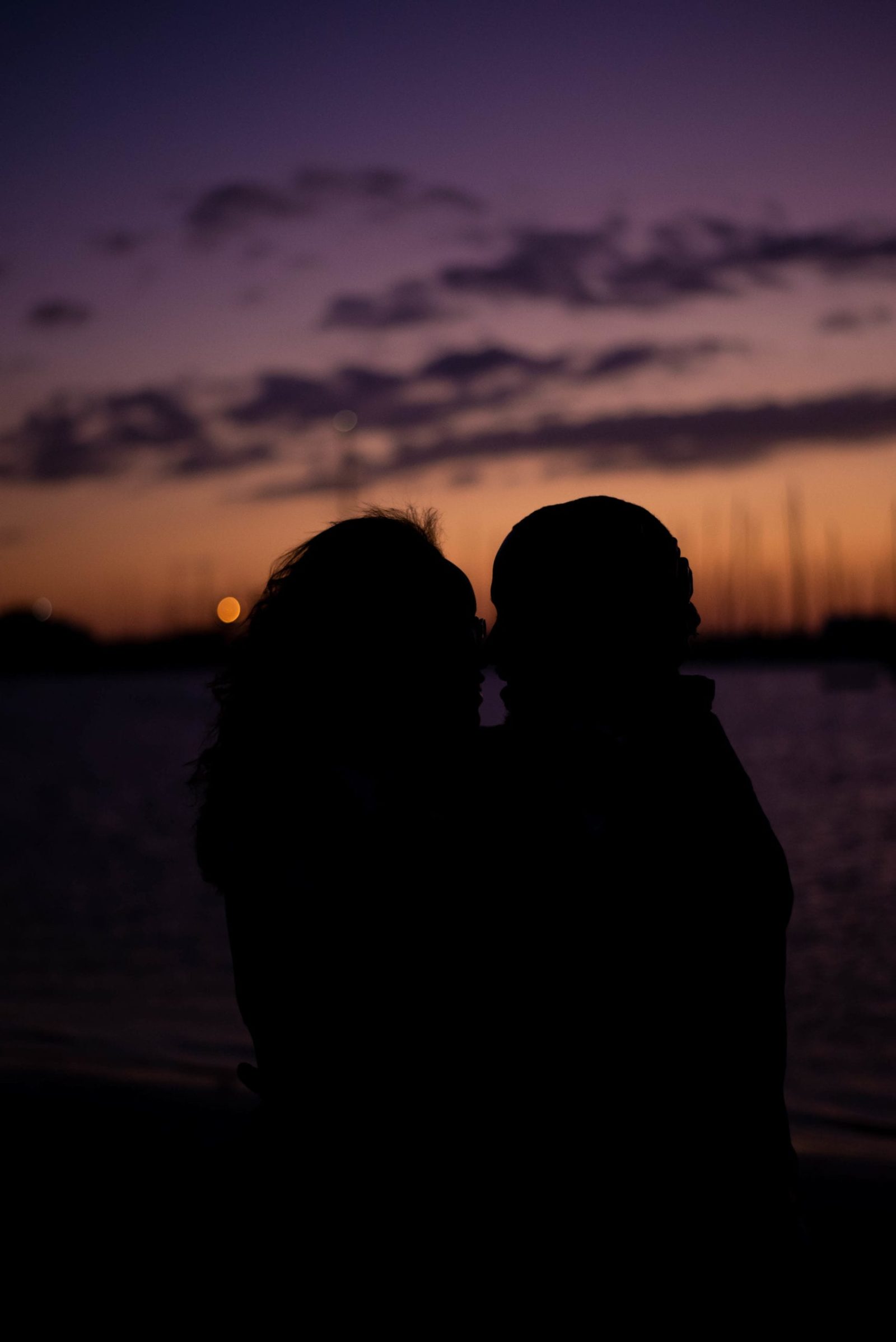 Davis island dog beach engagement photography session at sunset silhouette photo of couple kissing purple and orange sunset