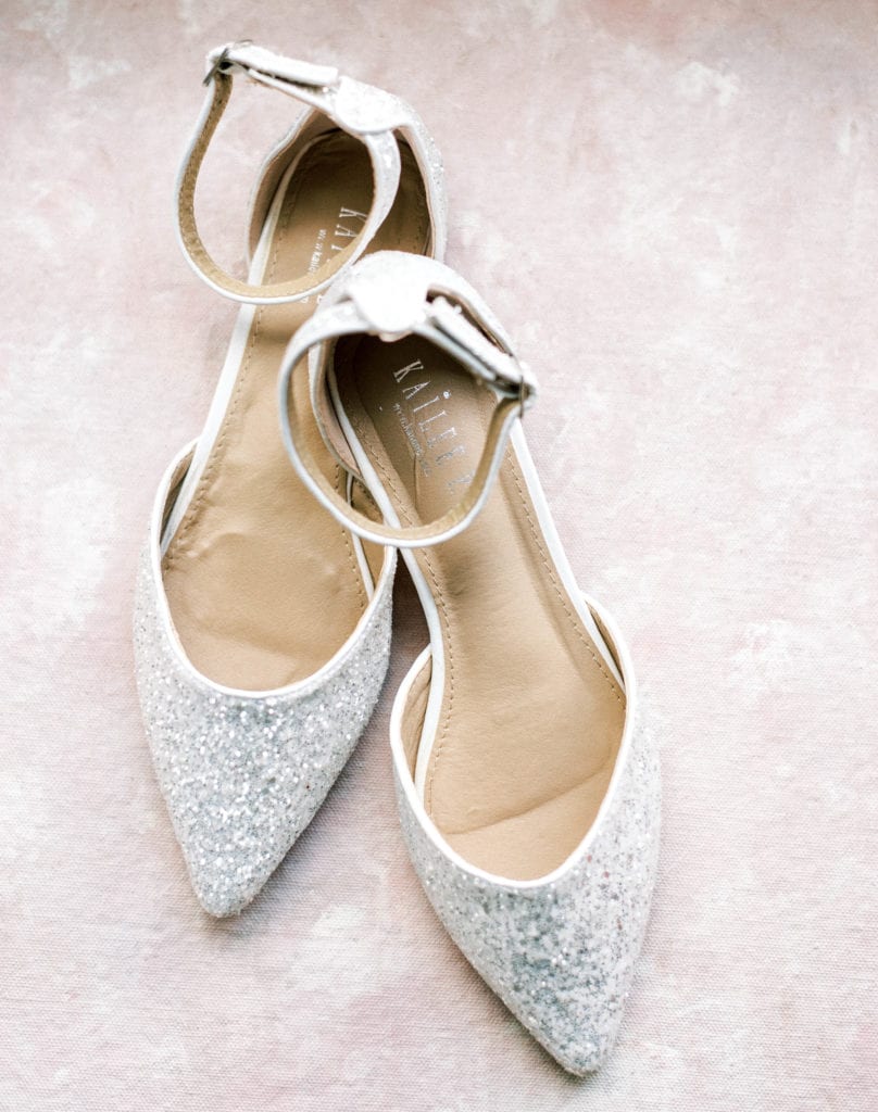 Silver sparkly wedding shoes on a pink background pointy wedding flats flat lay wedding photos