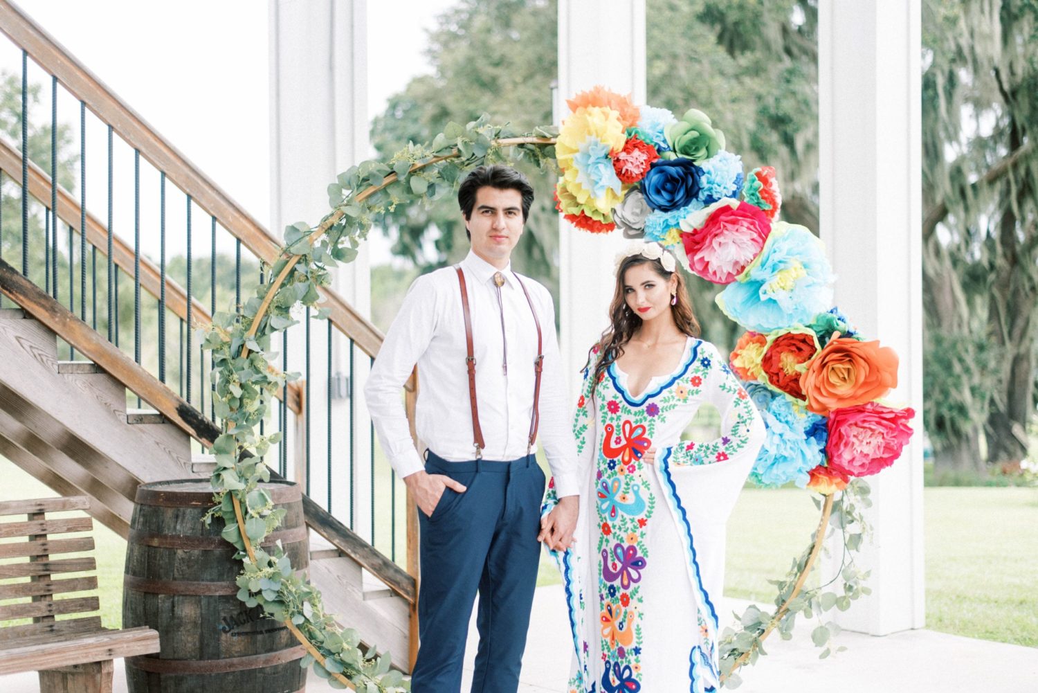 Covington Farm wedding like water for chocolate wedding colorful mexican wedding bride and groom standing by wedding arch looking at camera