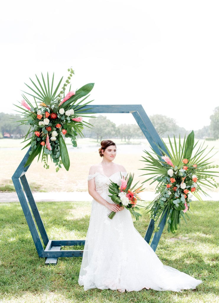 Orange tree golf club wedding bride portrait by flower arch outdoors ceremony