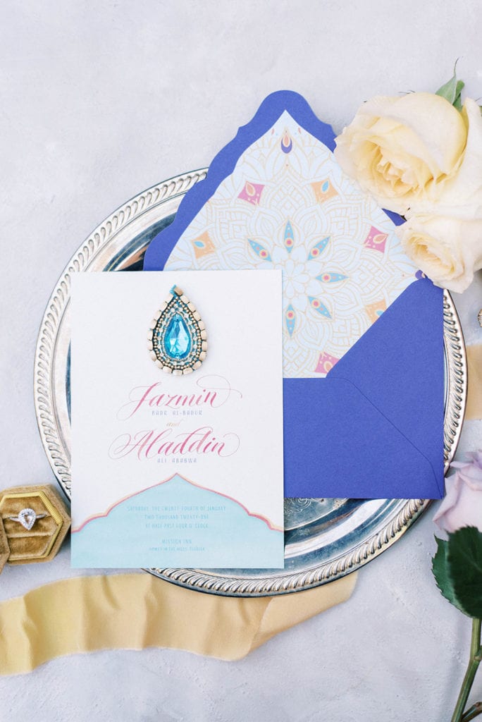 Aladdin themed wedding invitations in blue purple with gems