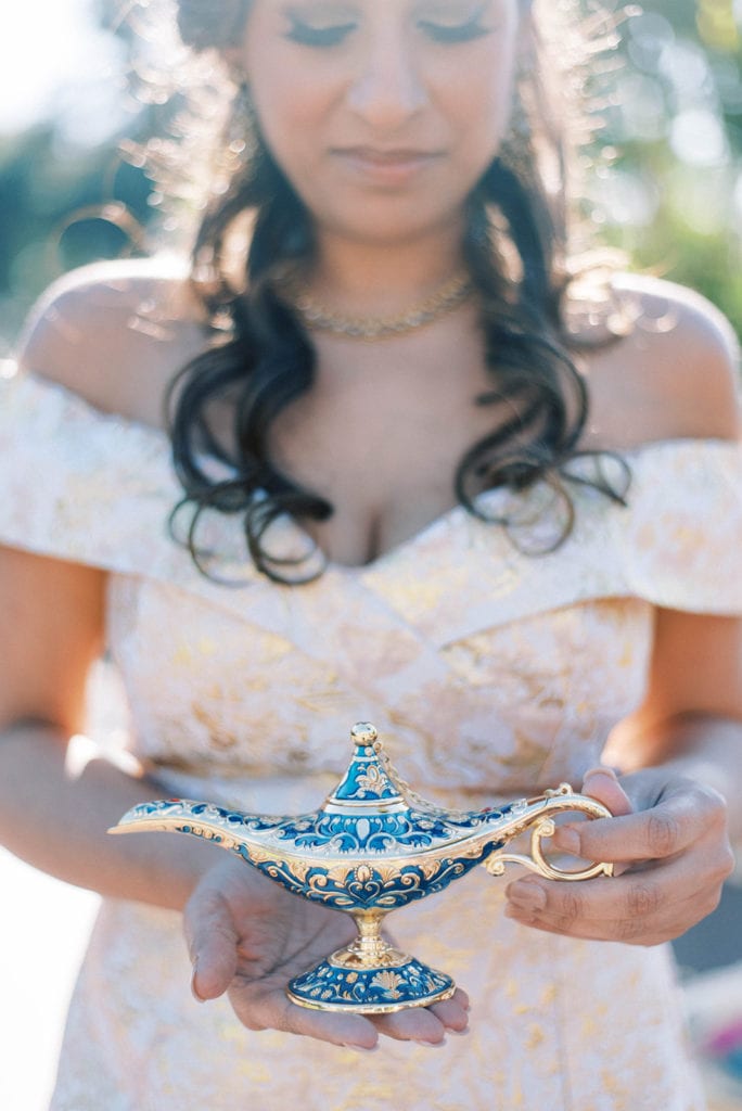 Bride holding aladdin genie lamp for disney wedding at mission inn wedding venue 