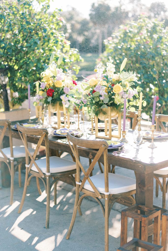 Outdoor reception table decor wooden table wood chairs gold floral centerpiece tangled themed wedding