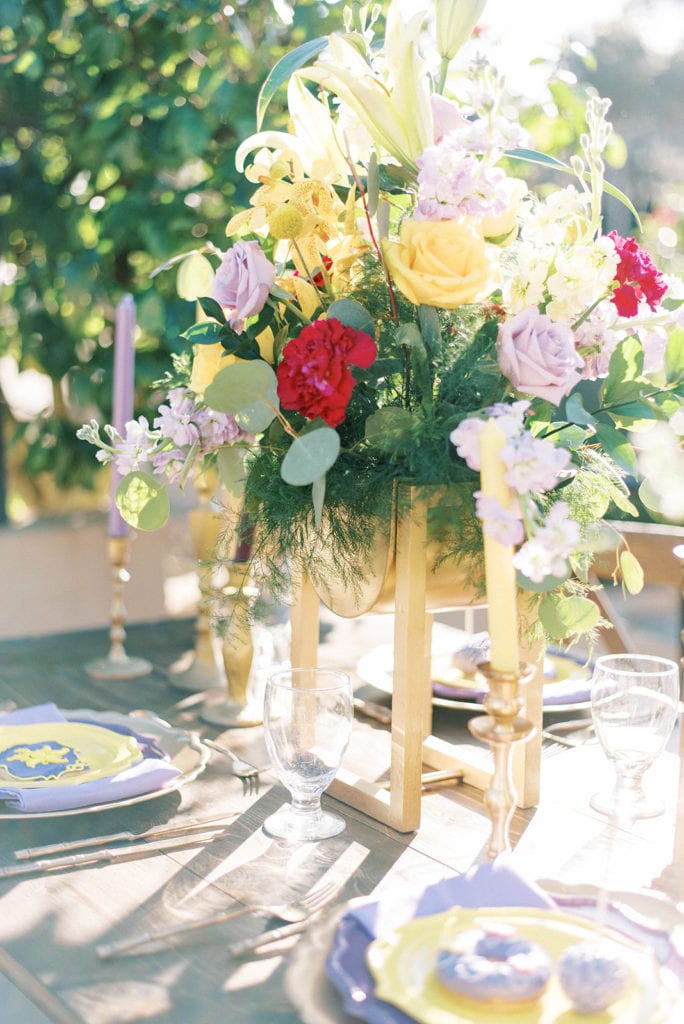 Tangled themed wedding at mission inn wedding venue reception table decor in purple and gold tones flower centerpiece