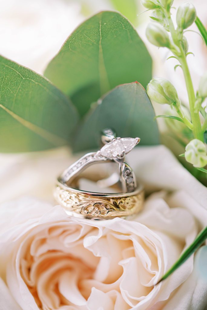 detail show of the wedding ring, engagement ring and florals