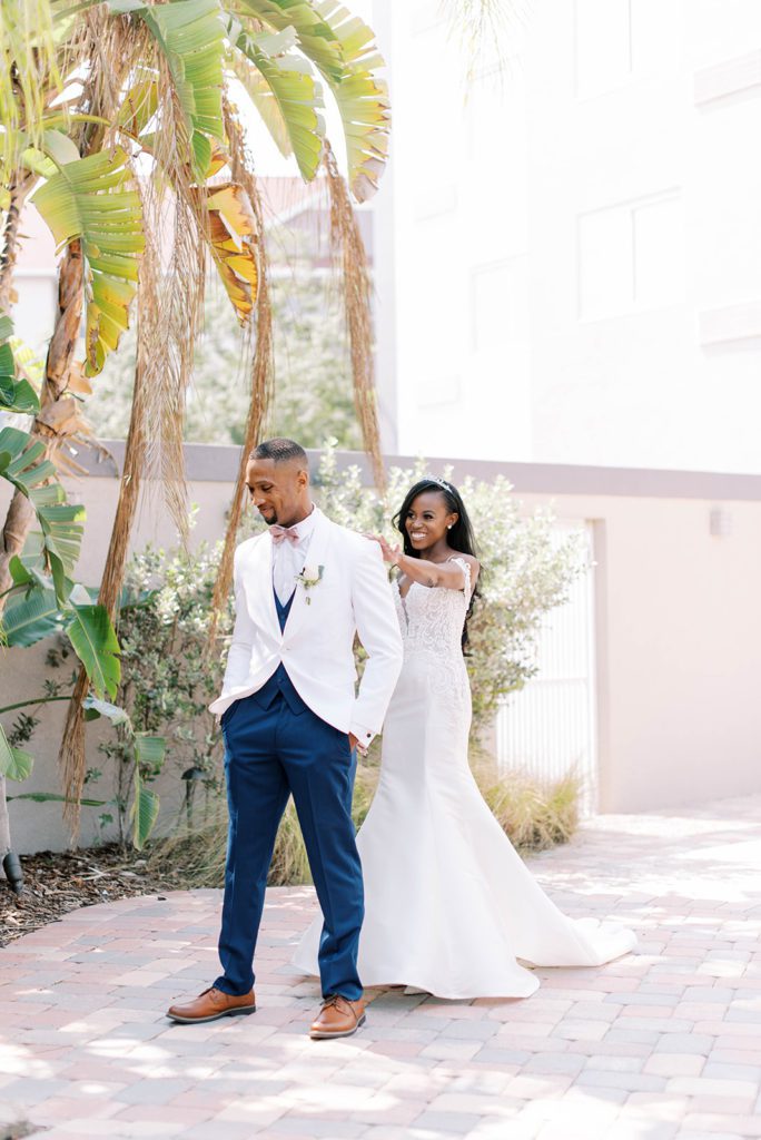 Florida bride coming up behind the groom and tapping him on the shoulder for the first look before the wedding ceremony at their Bayanihan Arts and Events Center wedding venue