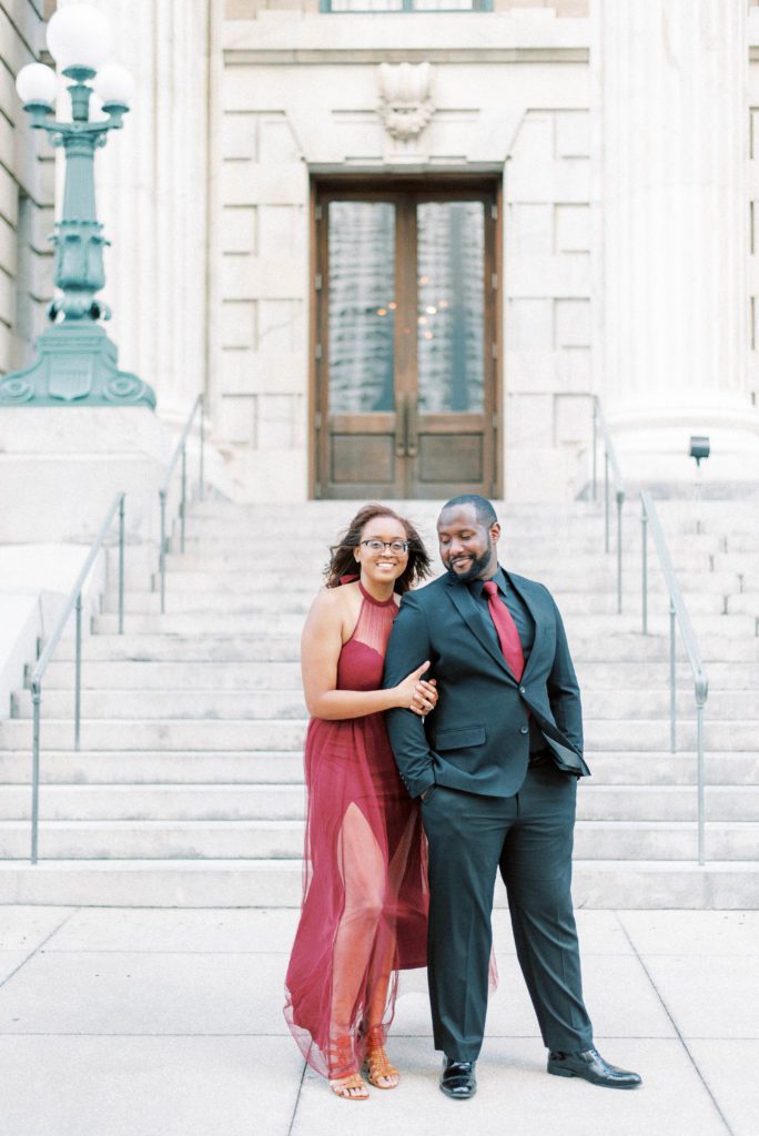 5 reasons why you must have an engagement session in Tampa Florida bride and groom posing for the camera at Le Meridien Tampa wearing a black suit and maroon dress best engagement session locations in Tampa