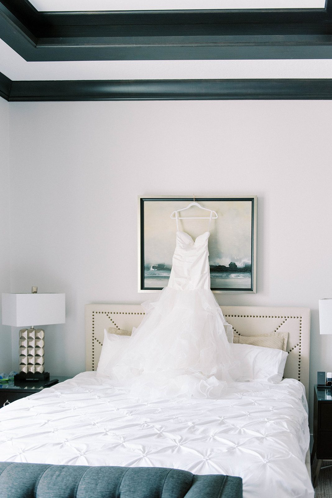 detail shot of wedding dress hanging above a bed at an airbnb micro wedding