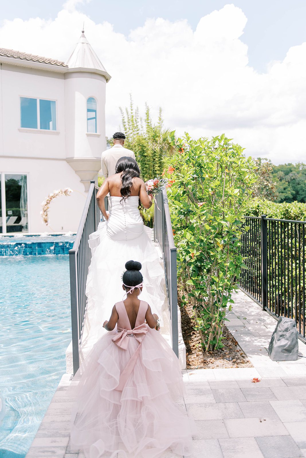 planning a first look on a Tampa wedding day with bride walking up stairs to see her groom for the first time on their wedding day next to a pool