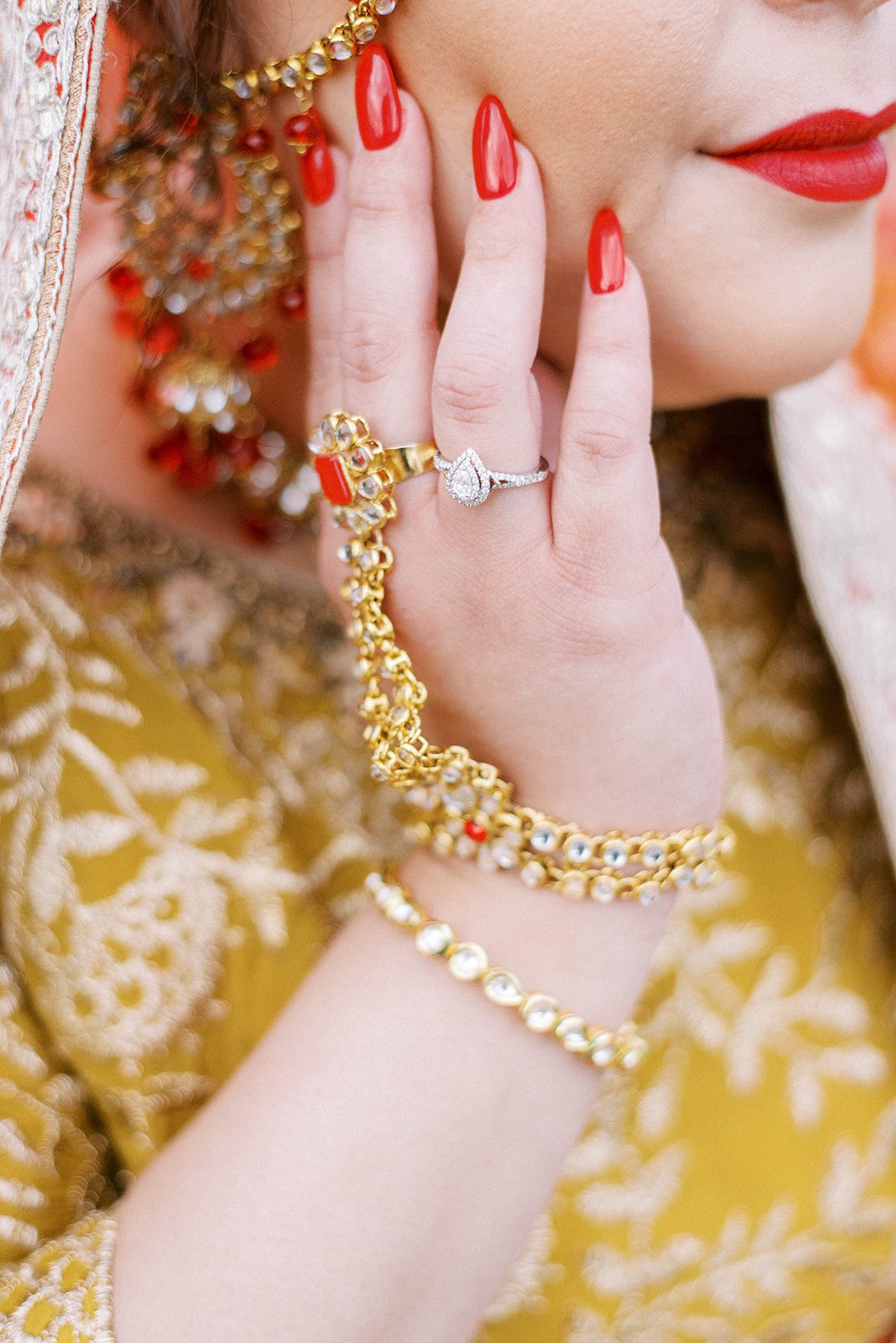 detail shot of brides hand, with her red nails and golden jewelry on her Tampa Indian wedding day