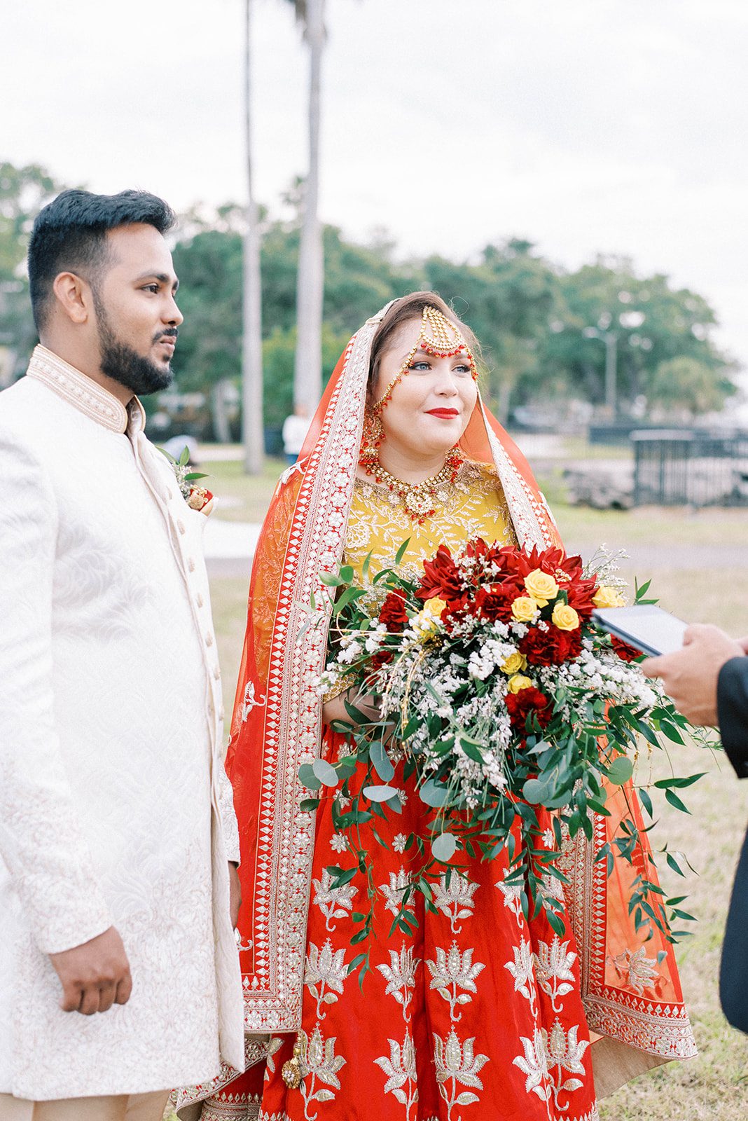Indian bride and groom in Florida getting married on a beach with their closest friends and family while wearing traditional clothing