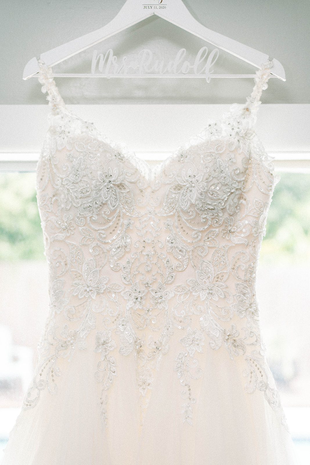 gorgeous perfect wedding dress hanging on a hanger for a bride on her wedding day