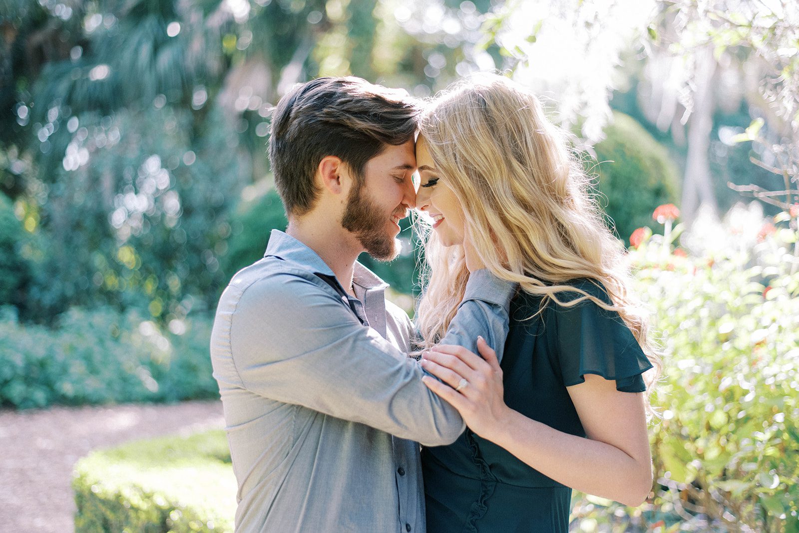 man with beard holds womans face with their foreheads together romantically in Bok Towers during their engagement session