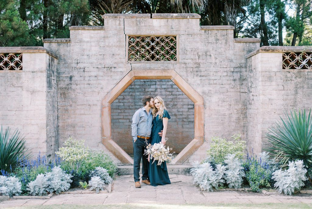 man and woman in Bok Gadrens taking engagement photos with the stunning walls and architecture that the garden provides in Tampa Florida
