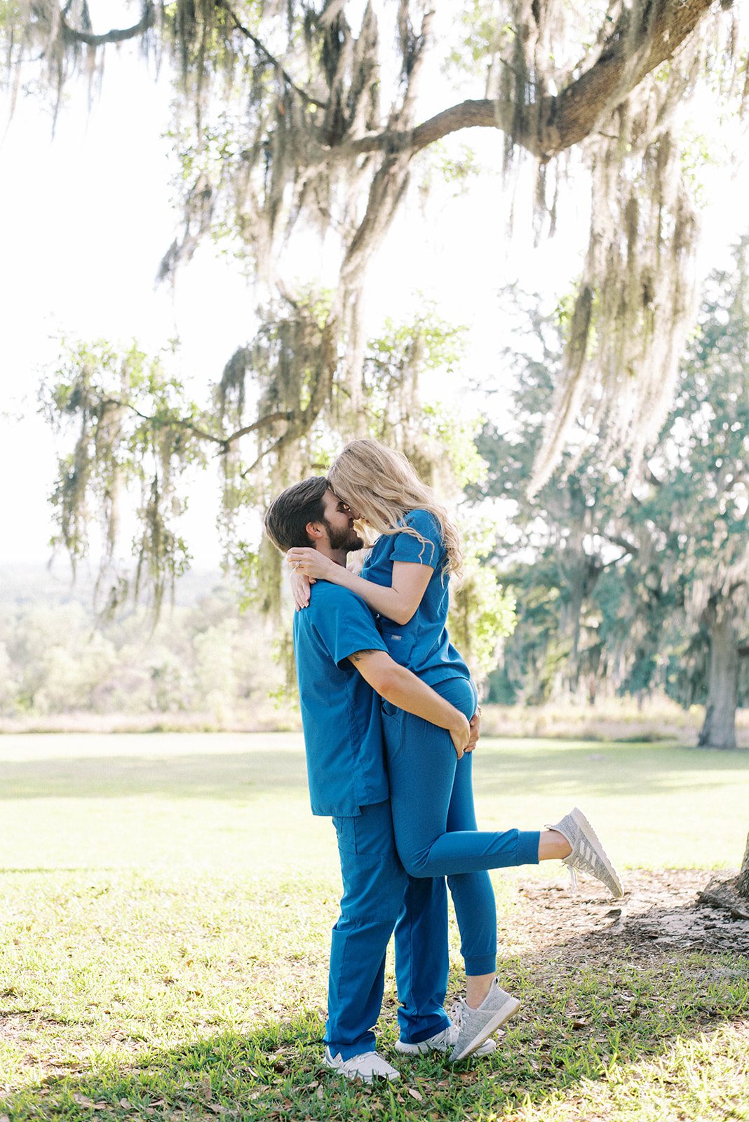 engagement session in Tampa Florida with man and woman in scrubs with man picking up woman as they laugh