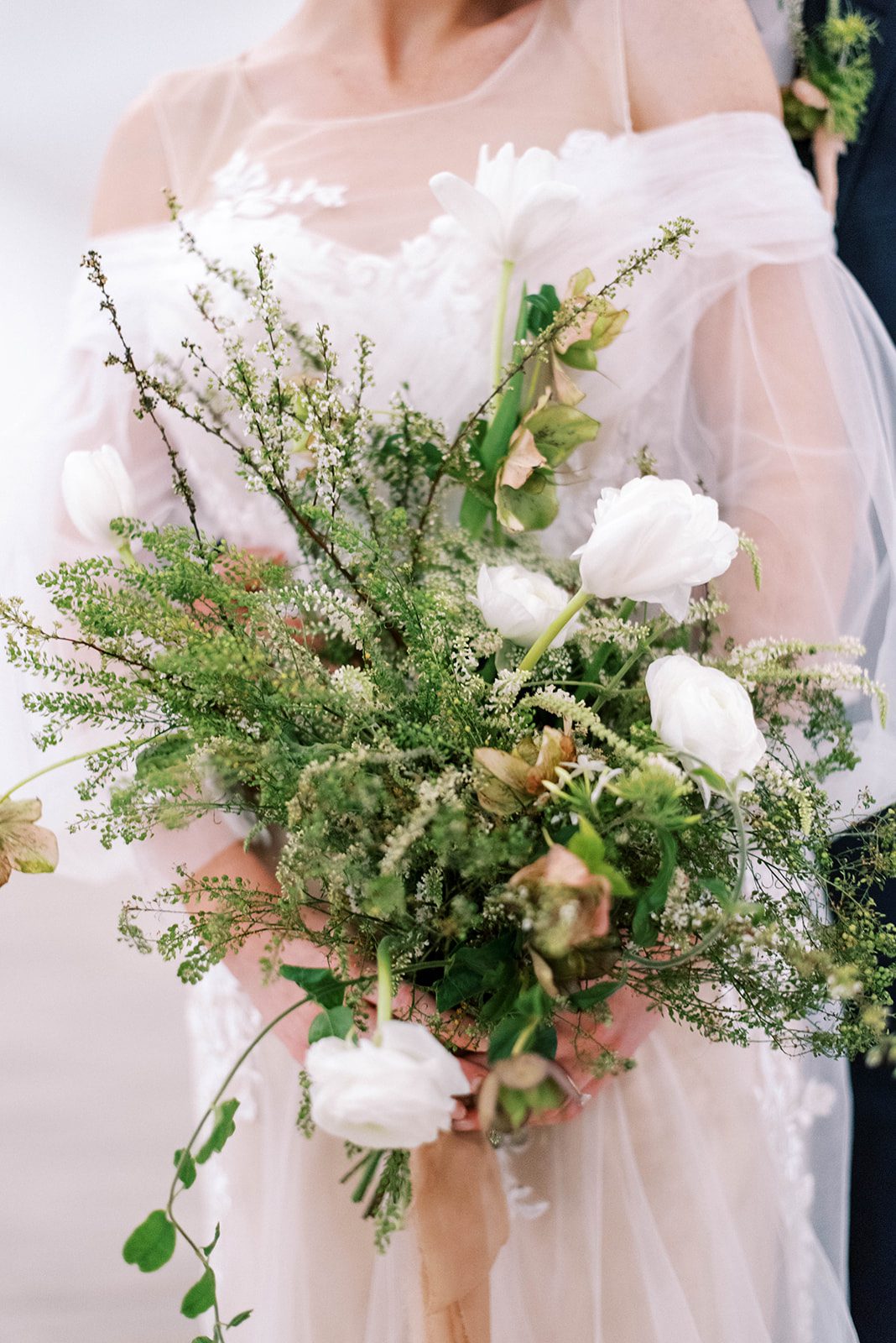 bridal bouquet in central Florida for a beach wedding, bouquet ismostly greenery with pops of white roses