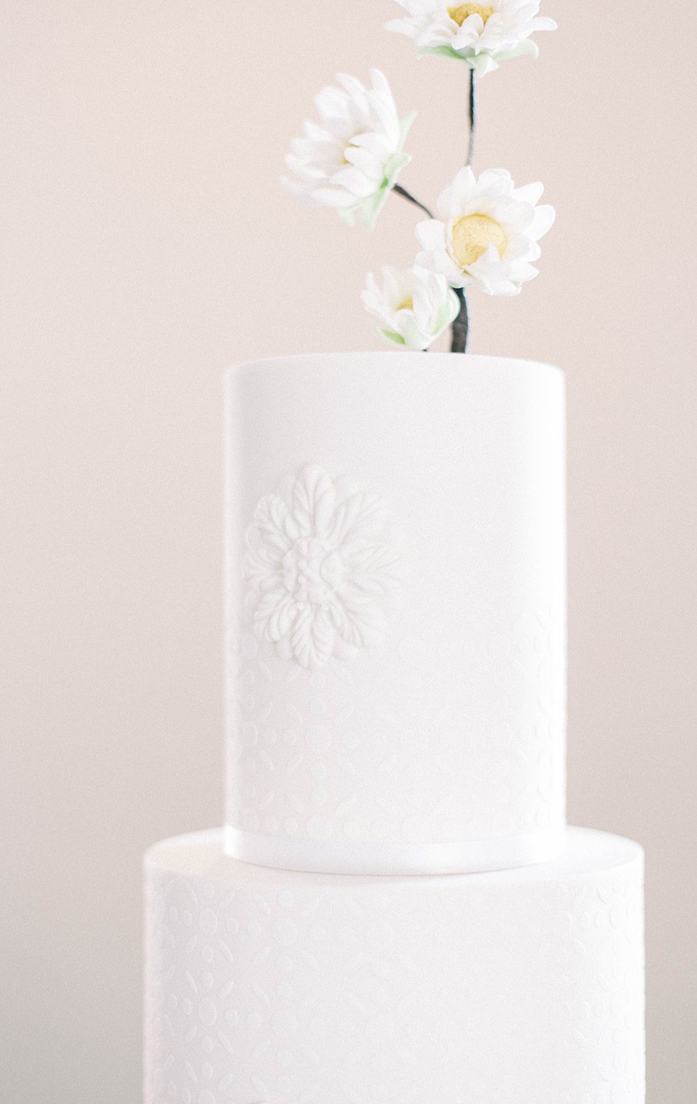 beautiful white wedding cake with daisy details
