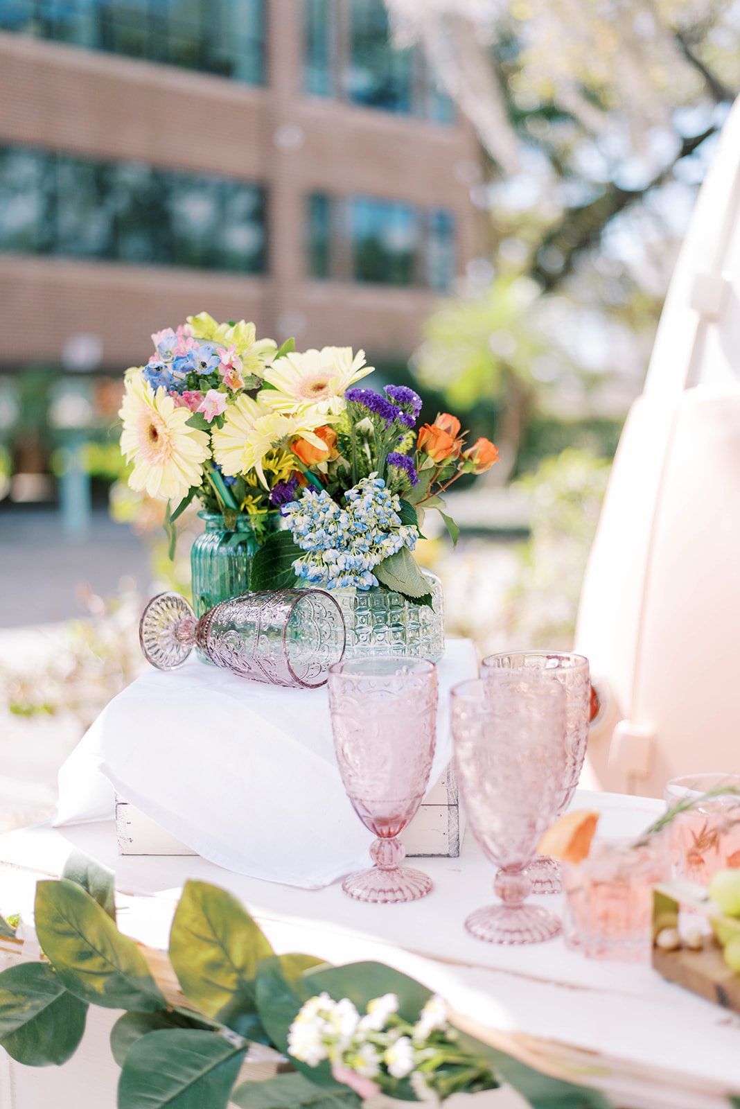 ornate glass cups and bright florals for a reception table space