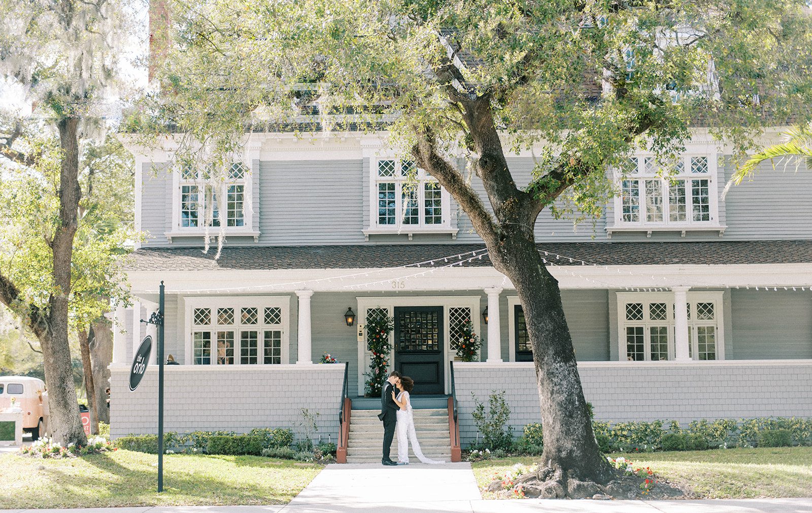 Bride and groom standning outside of The Orlo house in Florida on a bright sunny day in Florida