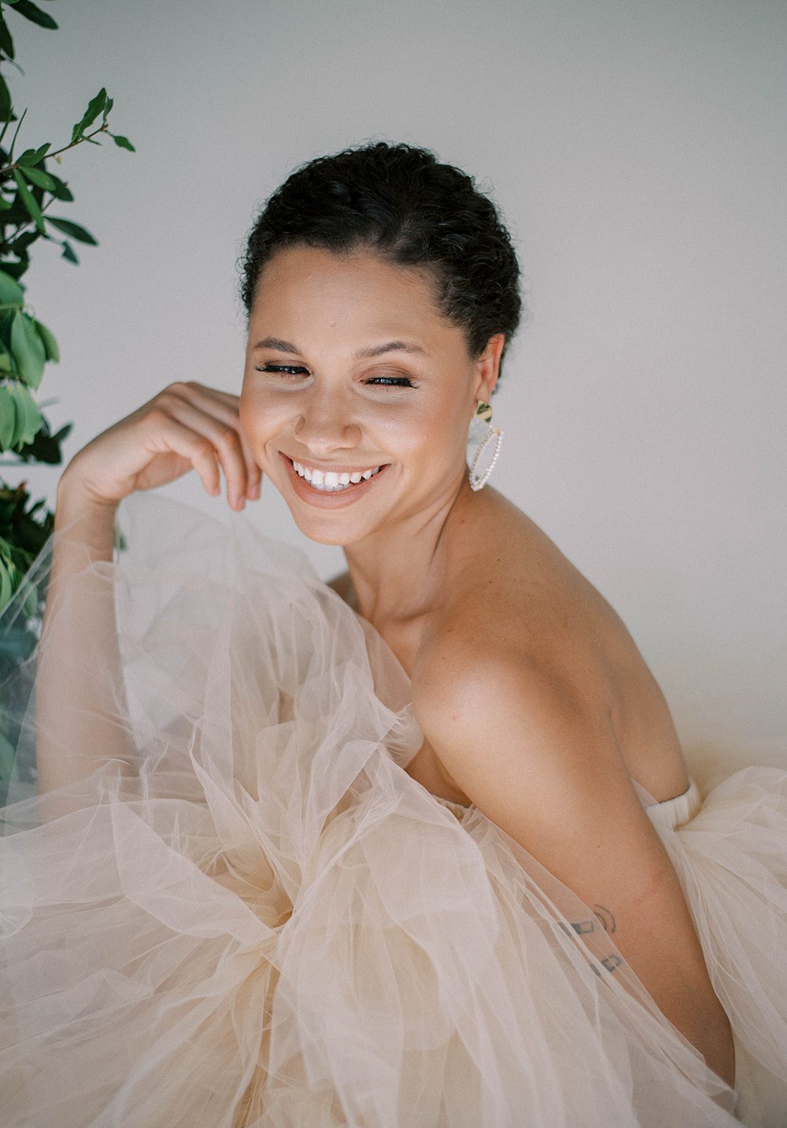 bride in an off white wedding dress smiling as she looks over her shoulder for a Tampa Bay wedding shoot