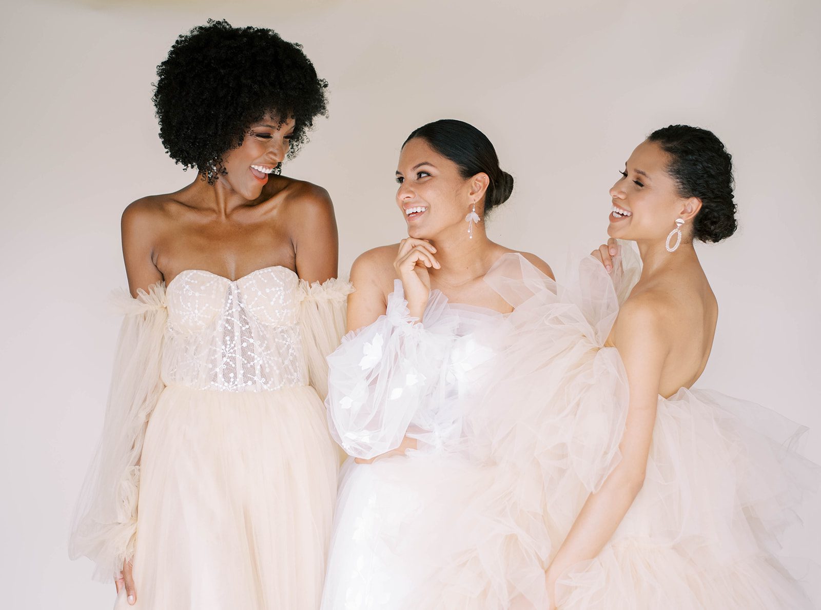 Three brides posing for colorful bridal fashion with neutral options 
