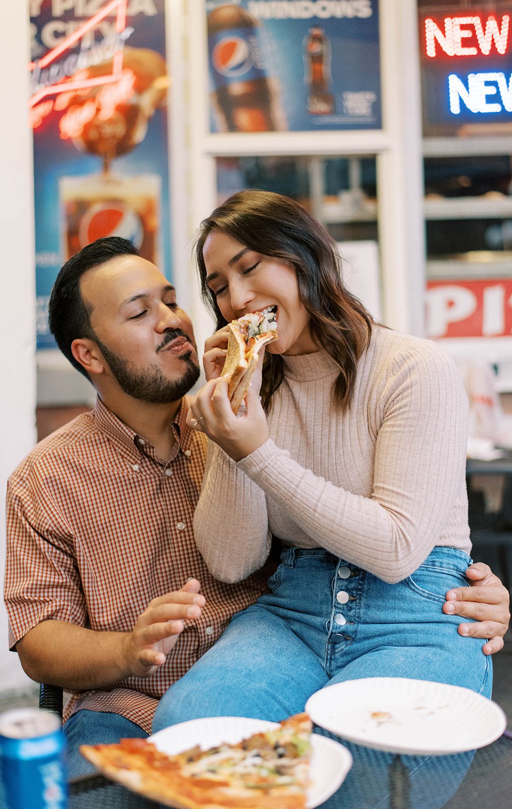 Ybor City pizza shop with man and woman eating pizza together for their engagement session while smiling in their casual attire