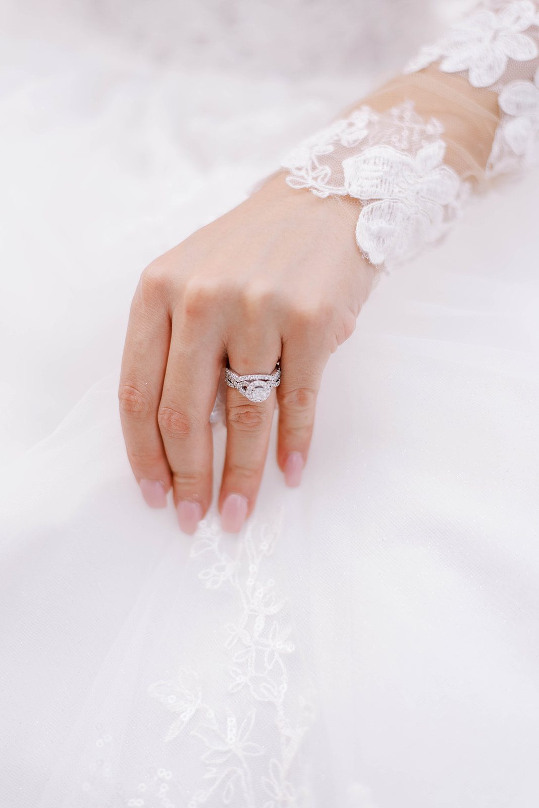 detail shot of wedding ring with Tampa bride holding her wedding dress
