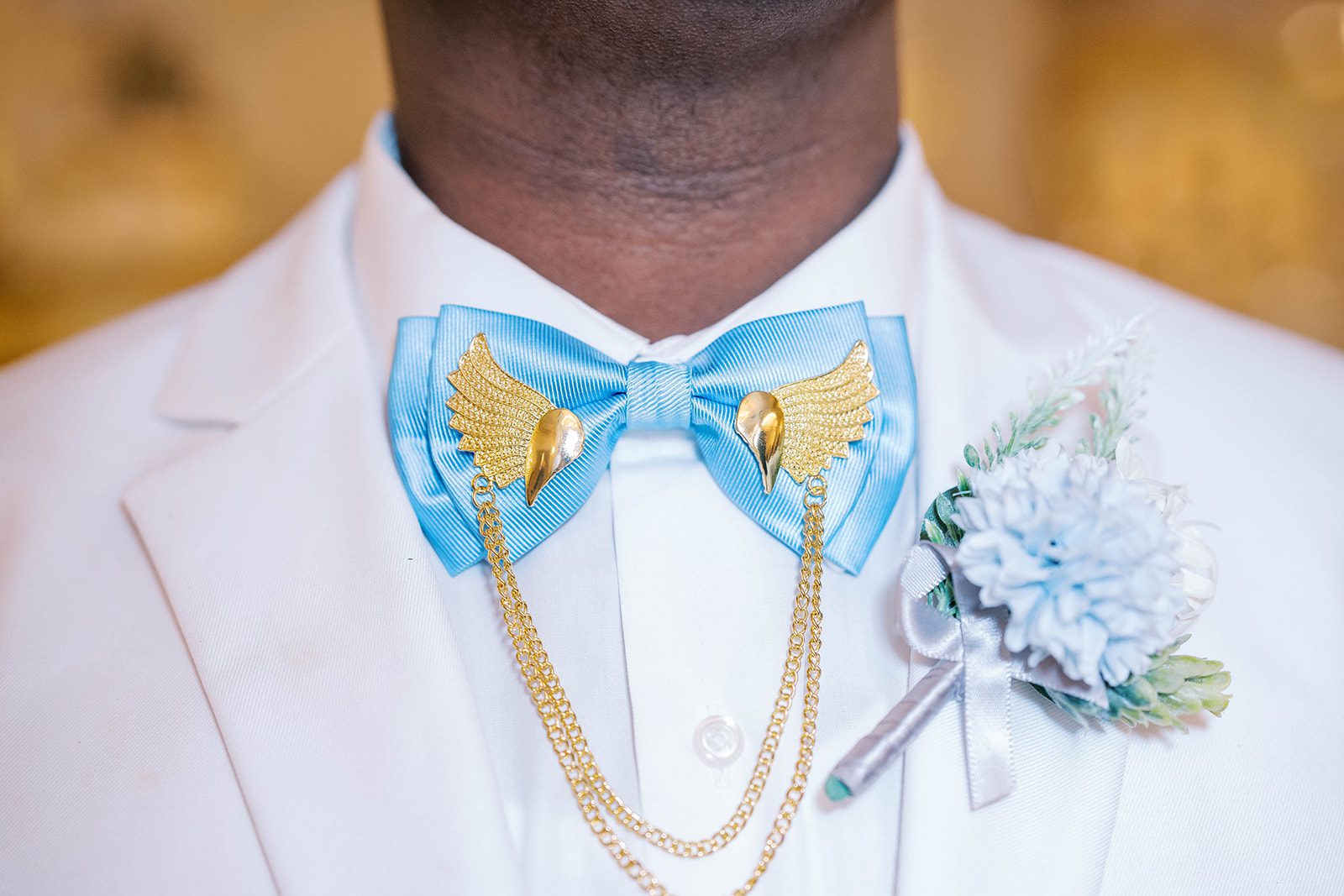 light blue bow ties with golden chains with a white suit for a groomsmen 