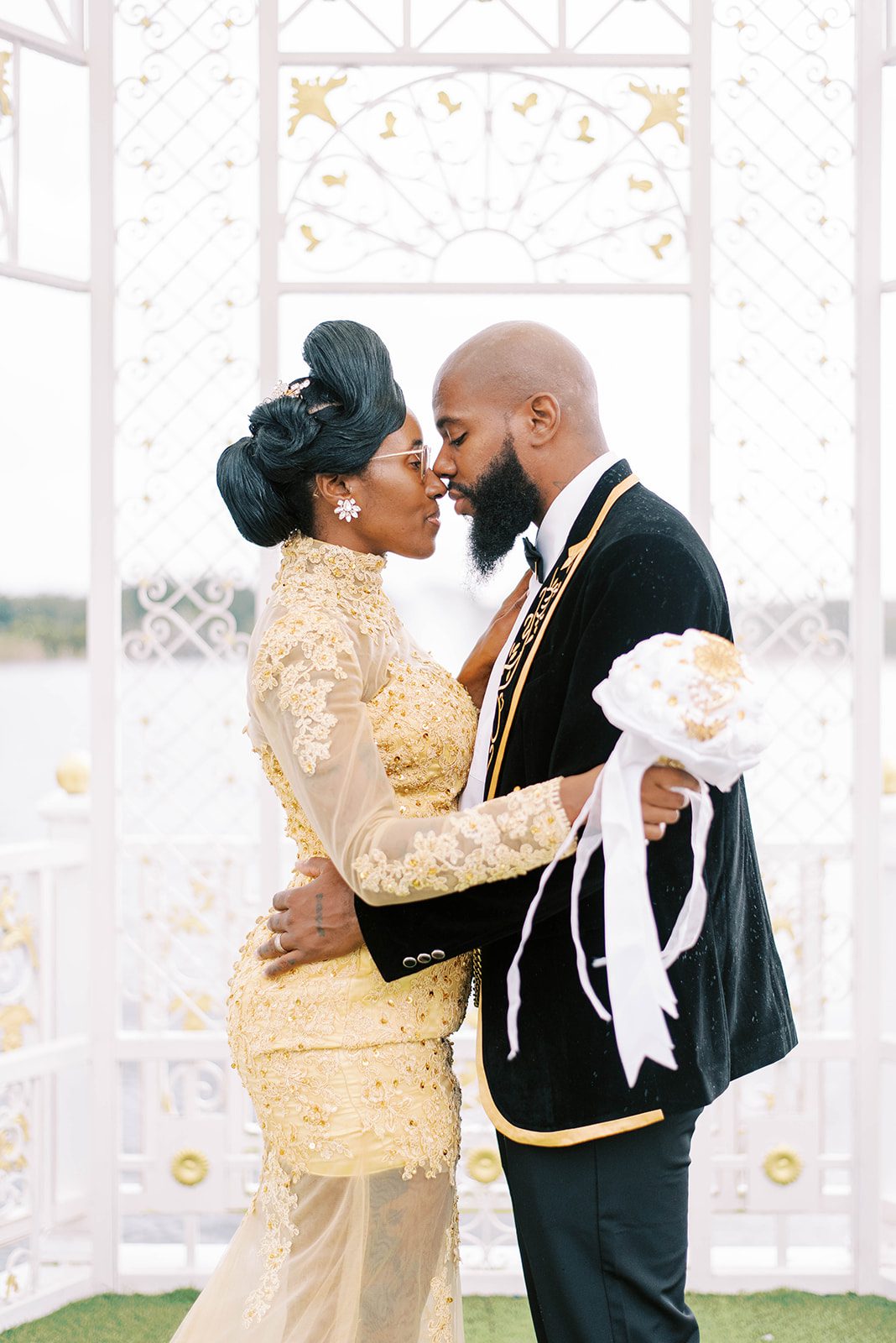 bride ina gold lace and sequence gown holds onto her groom who is in a black and gold embroidered suit at the Chic Venue golden palace in Tampa Florida