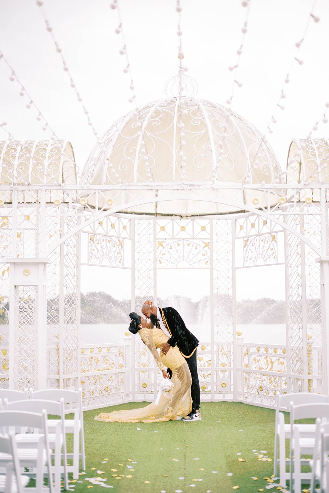 groom passioantely kissing his bride outside at their wedding venue in Tampa as the bride dips back