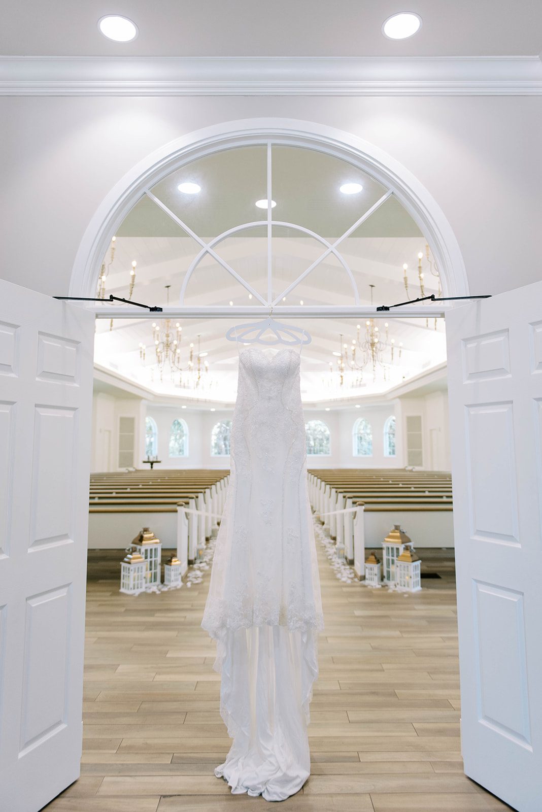 lace white strapless wedding dress hanging in a doorway into Harborside Chapel in Tampa Florida