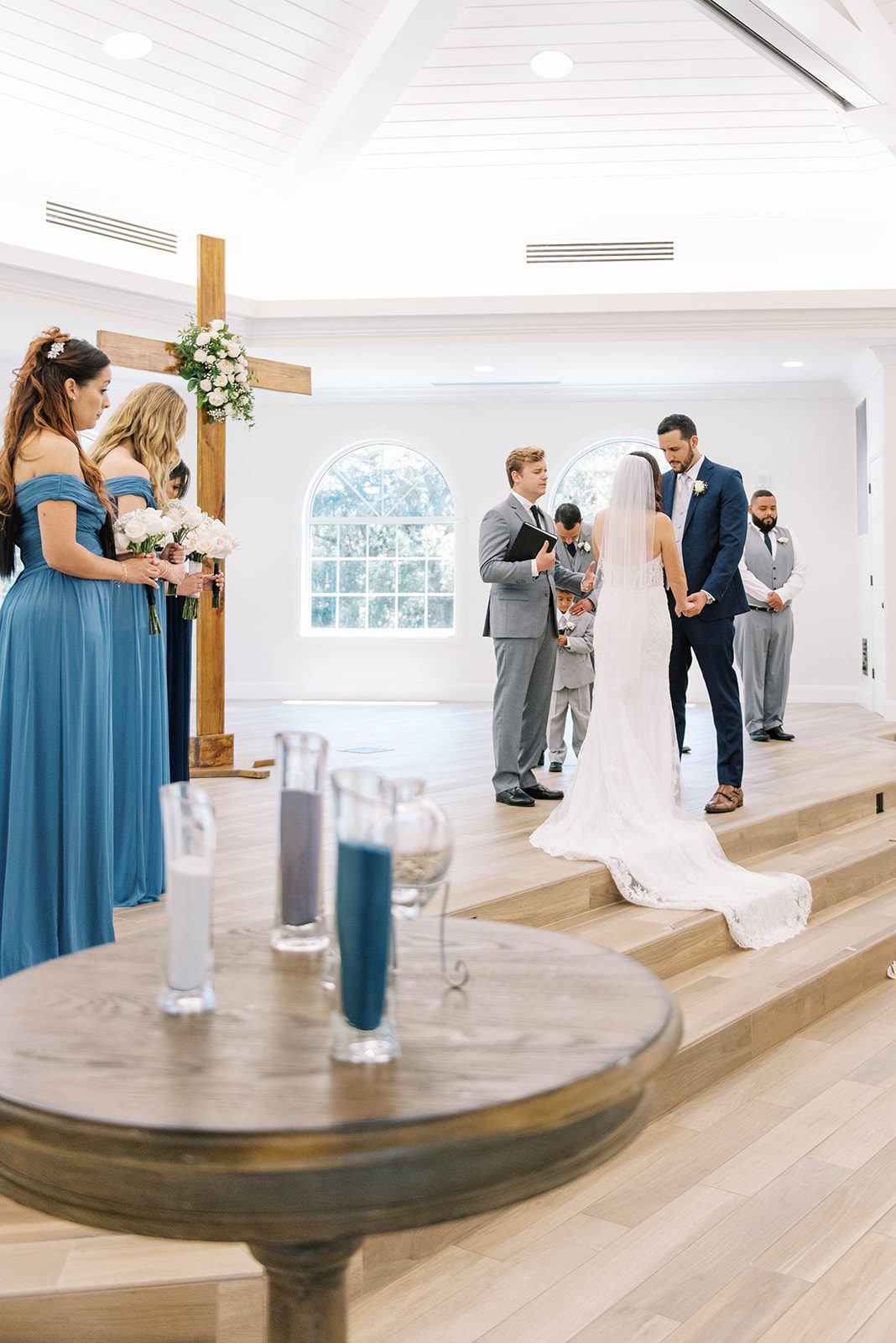 bride and groom standning at the alter in Harborside Chapel wedding venue in Tampa florida with their bridesmaids and groomsmen surrounding them