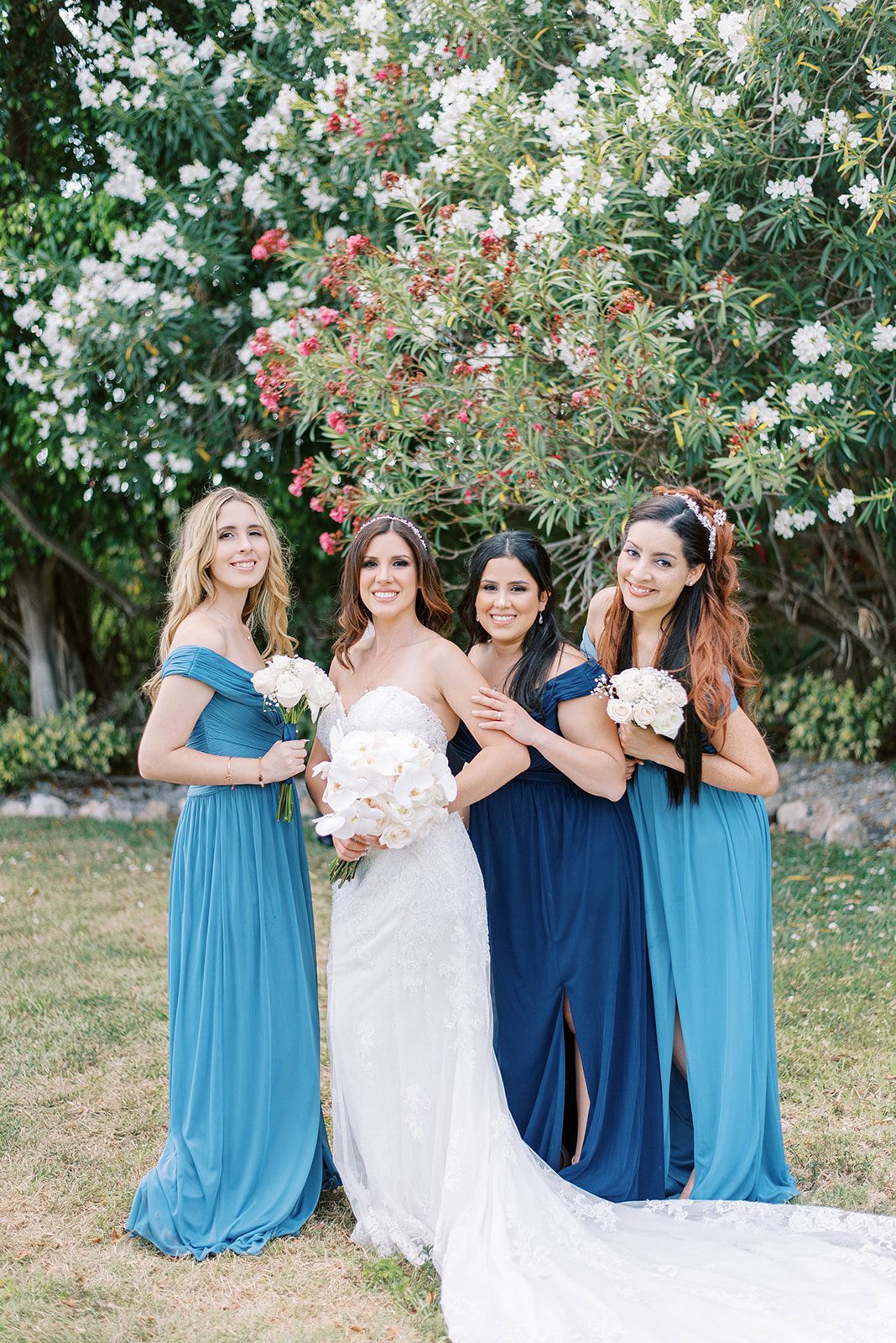 bride with her three bridesmaids in Tampa Florida for a destination wedding with bridesmaids all in different shades of blue