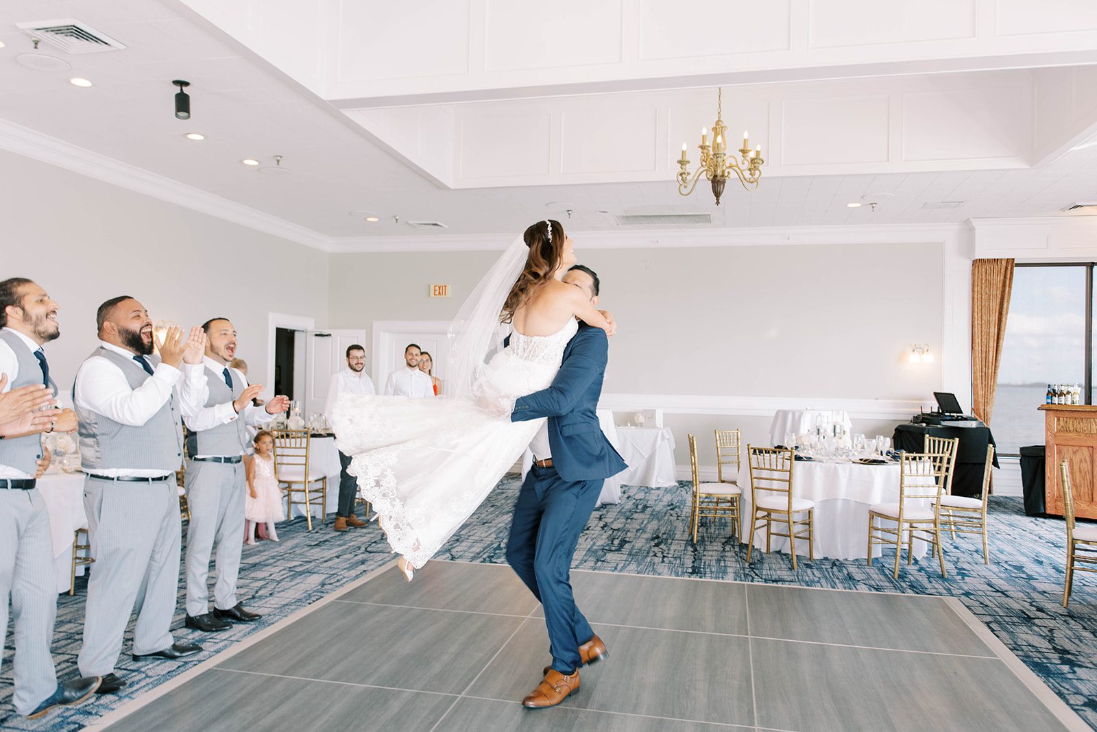 bride and groom dancing at the Rusty Pelican in Tampa Florida for their first dance with their wedding party cheering them on