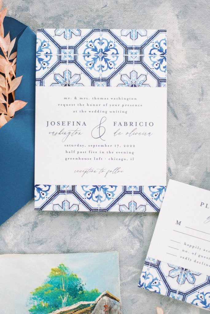 close up shot of picture perfect wedding invitation in white and blue on a marble backdrop