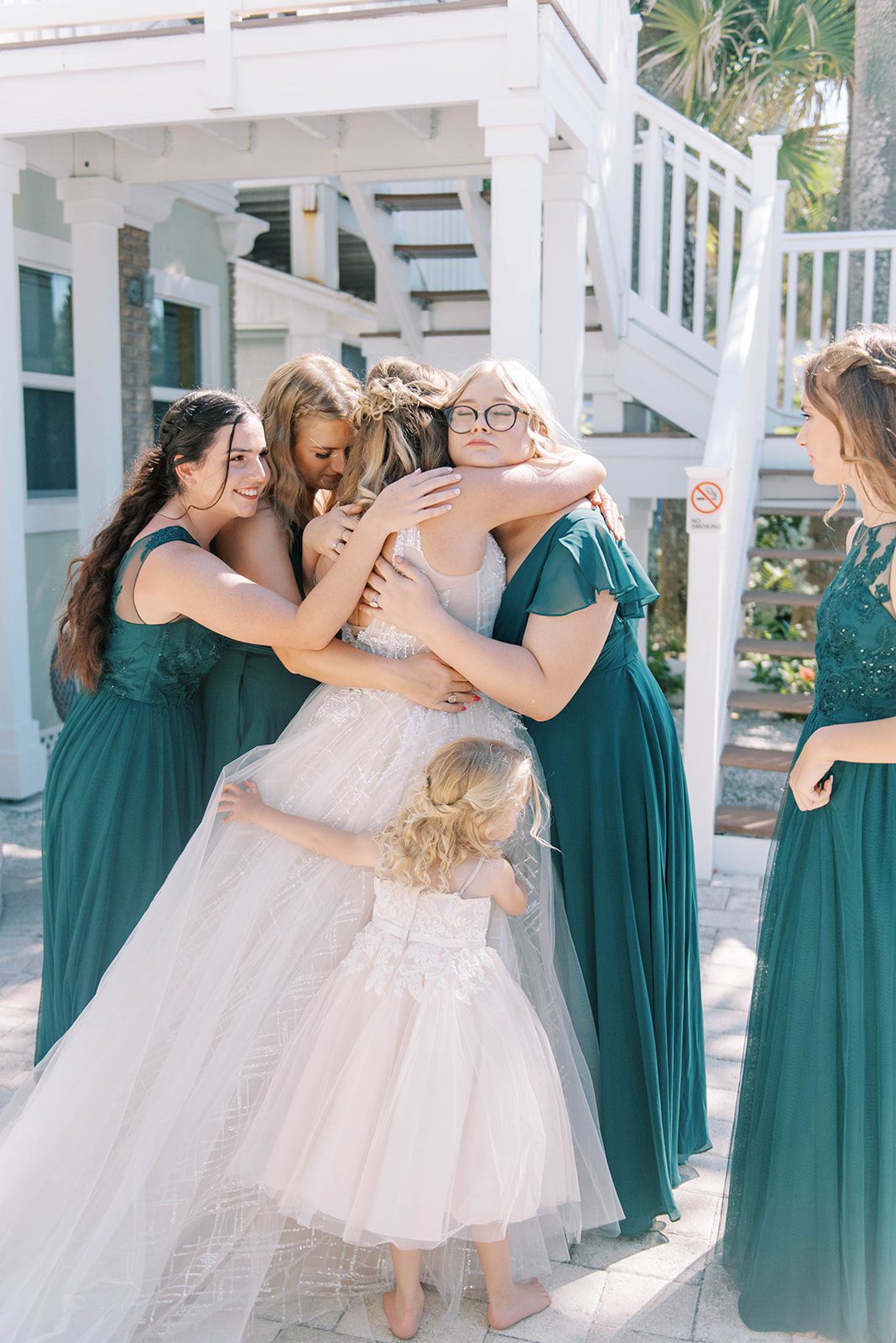 daughters hugging their mother during her first look with them on their Florida wedding day