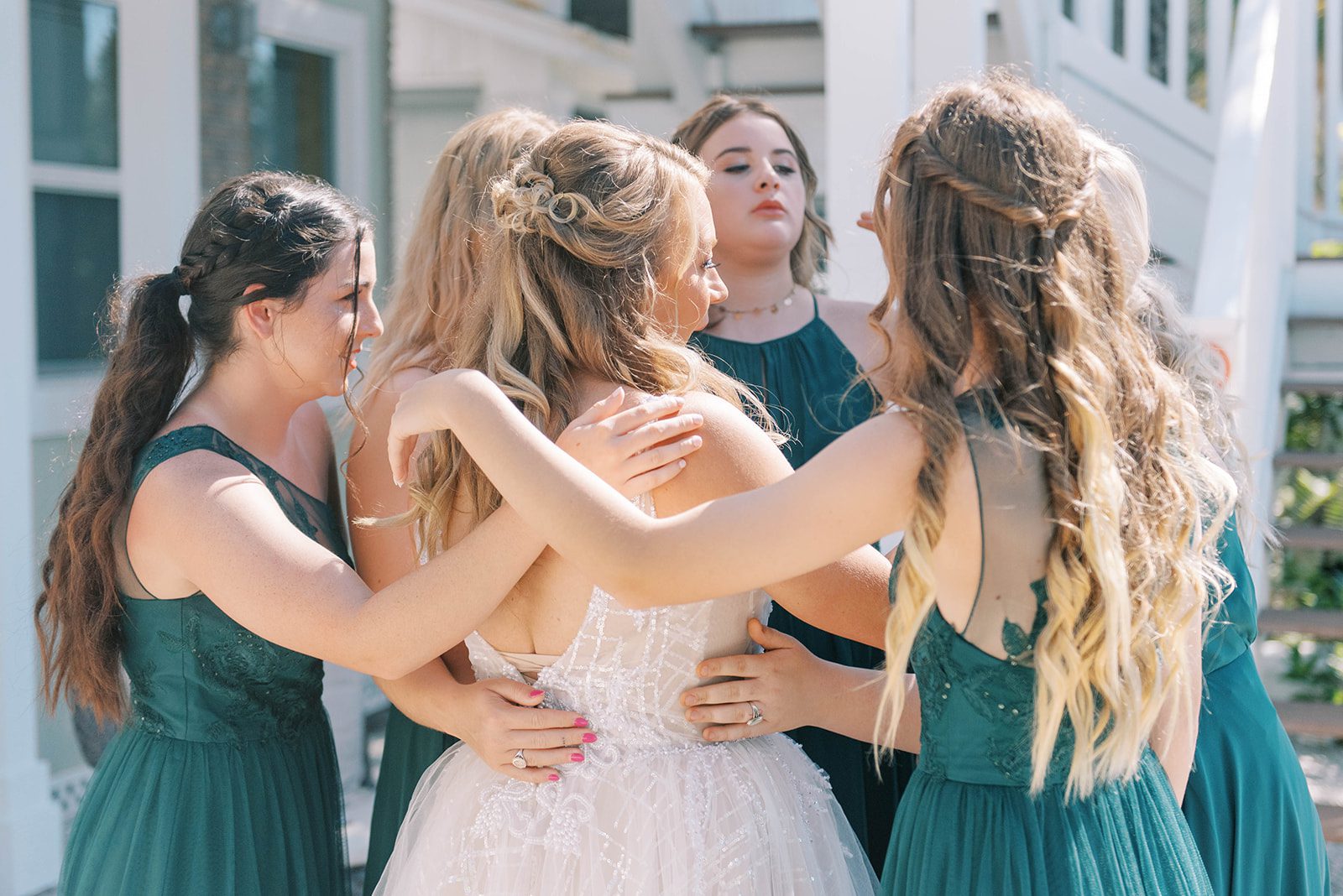 bride getting hugged by all of her daughters during her wedding in Florida