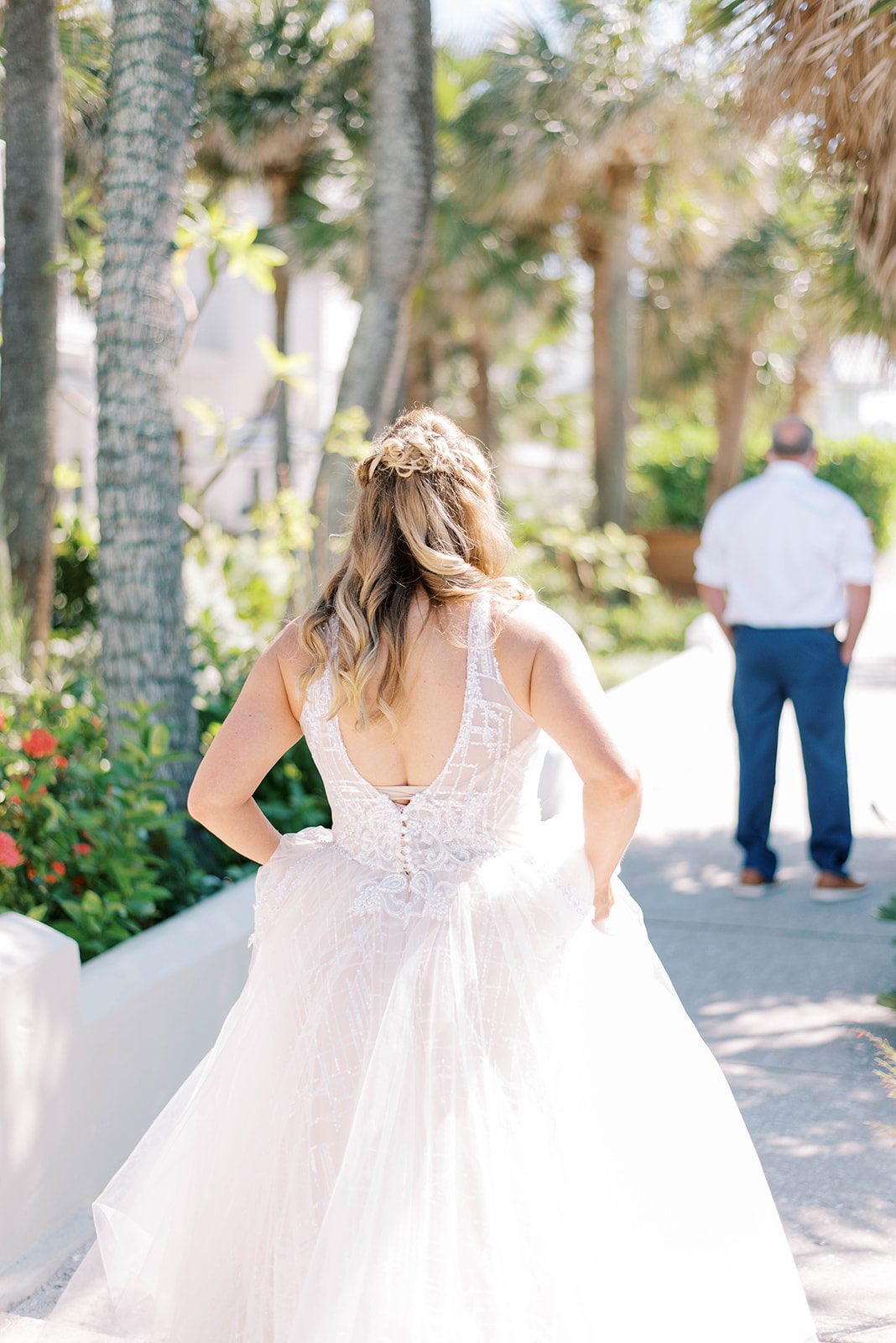 bride holding her gown as she walks up to her groom for their first together in Tampa