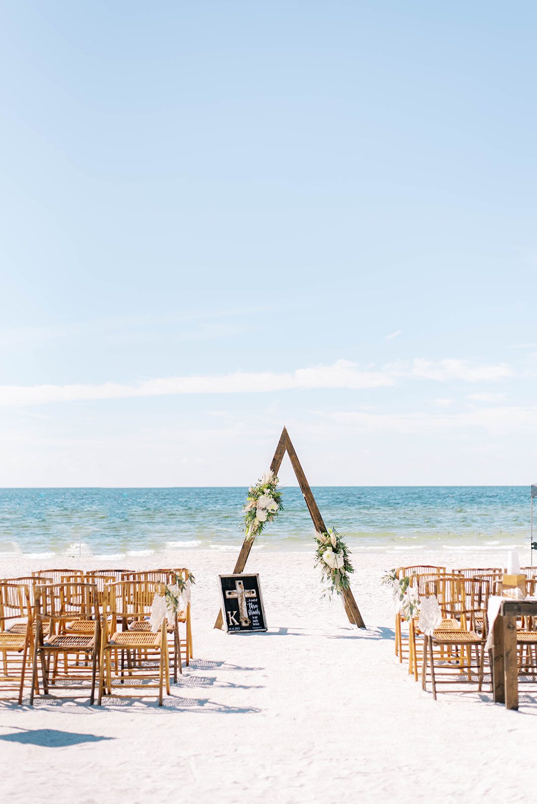 boho micro wedding on the beach with a triangle arch and rattan folding chairs in St. Petersburg Florida