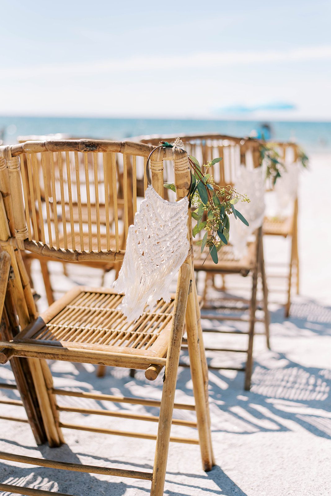 Boho wedding decor with white macramé detail on the chairs at the ceremony