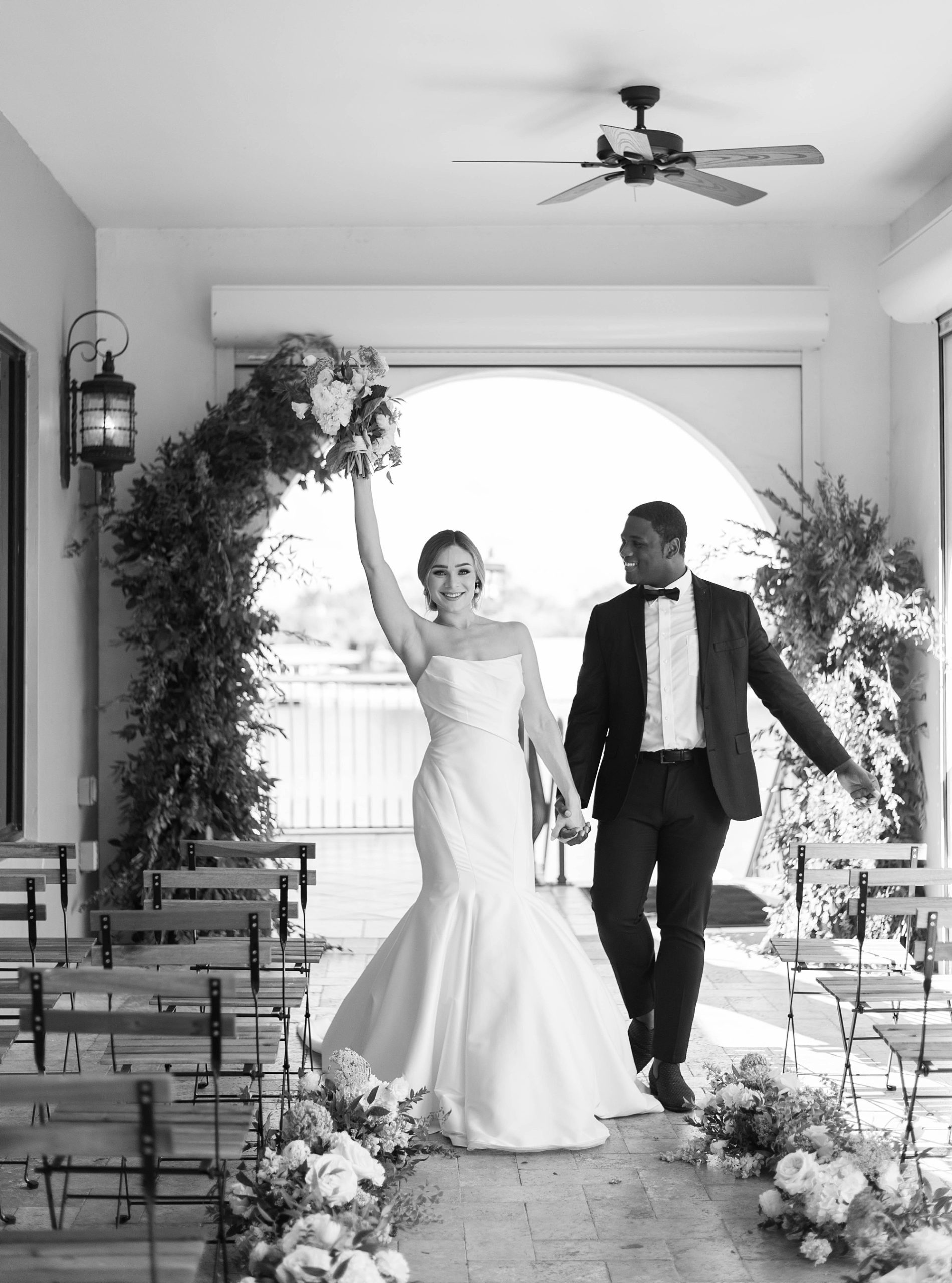 bride cheers with bouquet in the air after Hotel Zamora wedding ceremony on patio