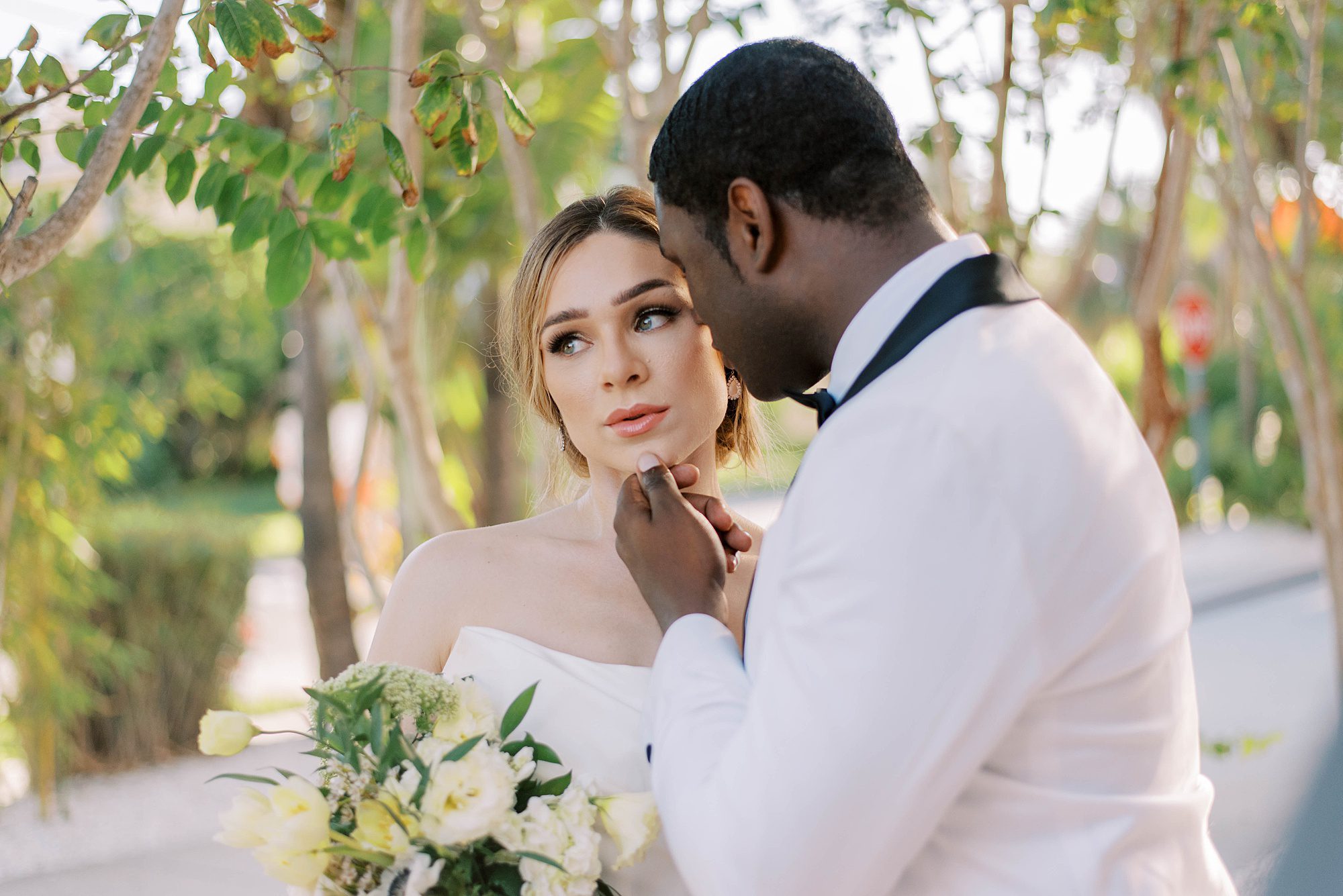 groom holds bride's chin during portraits for Hotel Zamora wedding day
